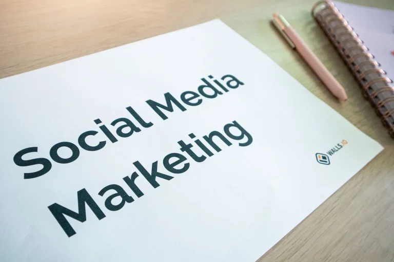 Folha com o título Social Media Marketing pousada numa secretária de madeira