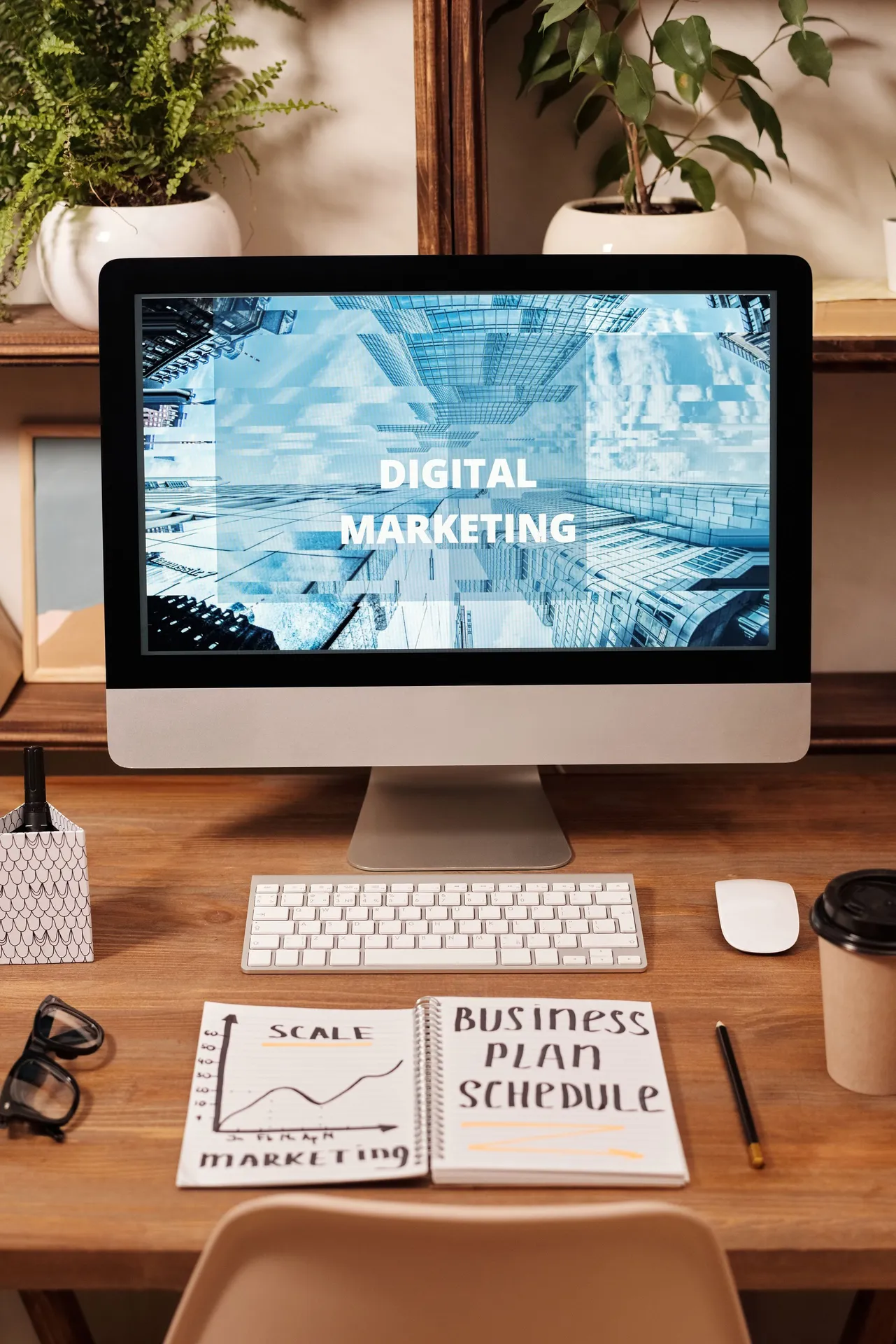 Computador numa secretária com as palavras Digital Marketing no ecrã e um caderno ao lado
