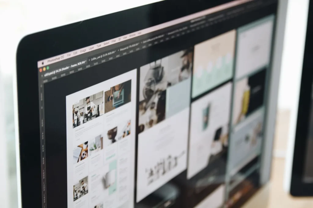Monitor com o design de um website em várias páginas, aberto num programa de edição