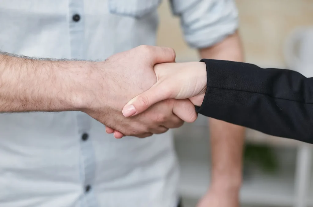 Aperto de mão entre duas pessoas no fecho de um acordo